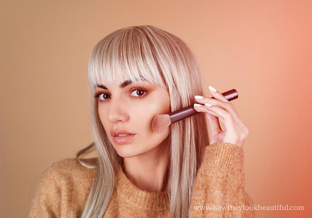 woman applying bronzer